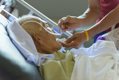 Elderly fed by care givers
